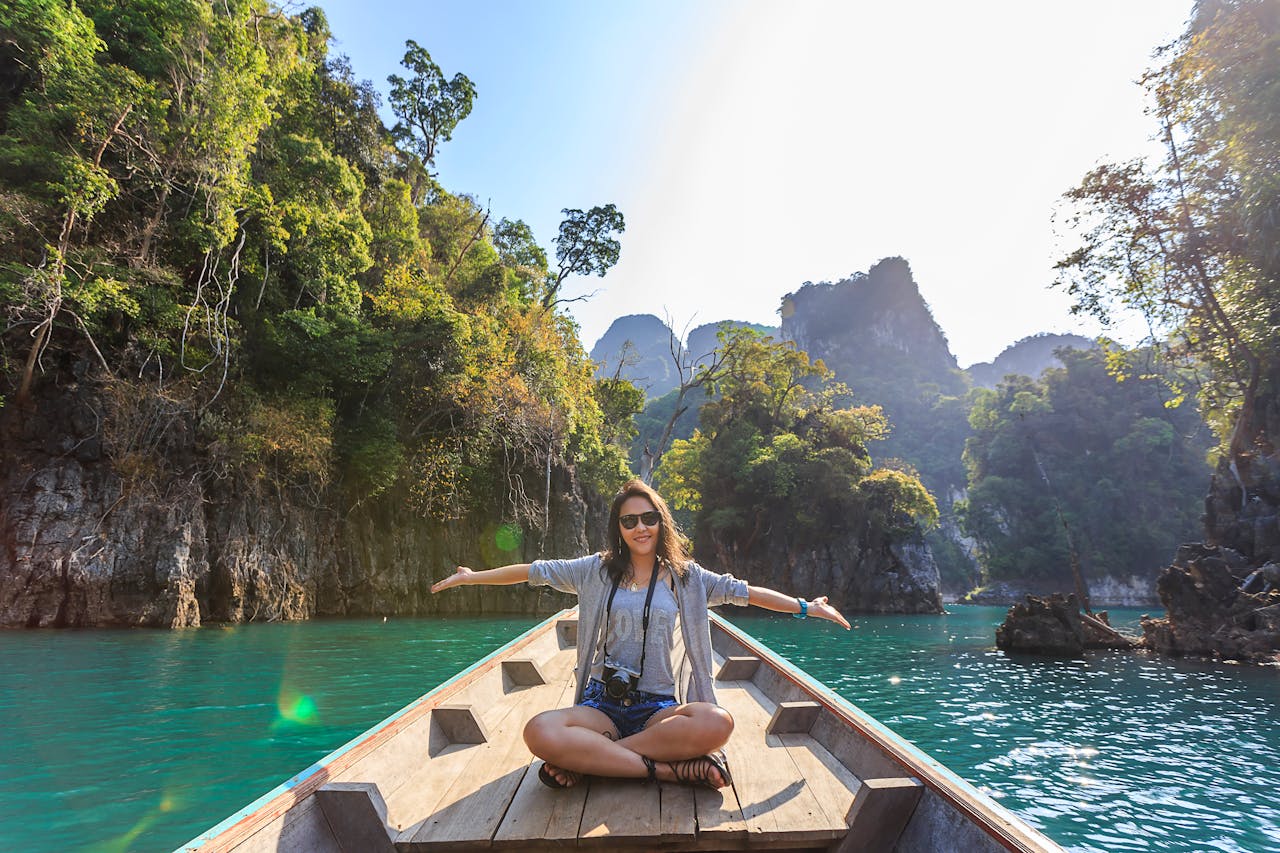 Photo of Woman Sitting on Boat Spreading Her Arms